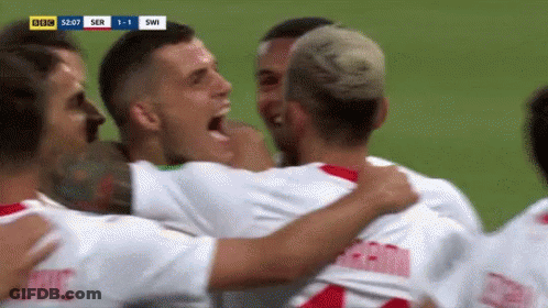 A Group Of Soccer Players Are Hugging Each Other And Celebrating A Goal . GIF