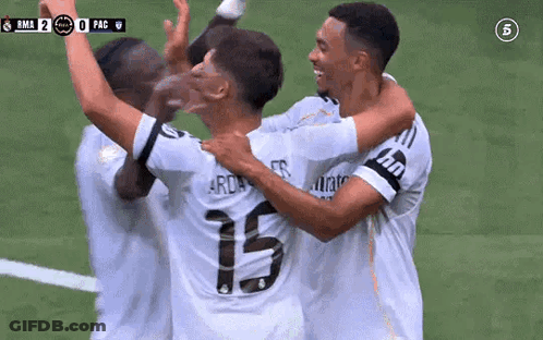A Group Of Soccer Players Are Hugging Each Other And Celebrating A Goal . GIF