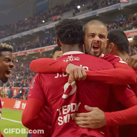 A Group Of Soccer Players Are Hugging Each Other And One Has The Number 2 On His Back GIF