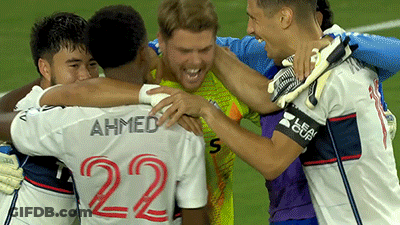 A Group Of Soccer Players Are Hugging Each Other And One Of Them Has The Number 22 On His Back GIF