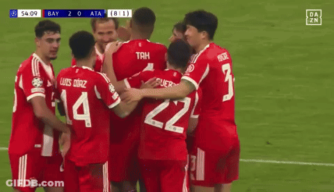 A Group Of Soccer Players Are Hugging Each Other On A Field . One Of The Players Has The Number 14 On His Jersey . GIF