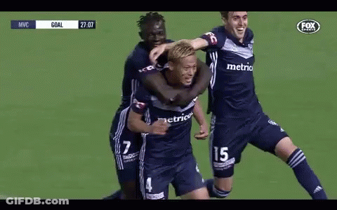A Group Of Soccer Players Are Hugging Each Other On A Field . GIF