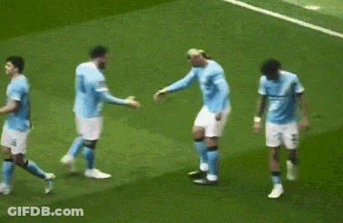 A Group Of Soccer Players Are Hugging Each Other On A Field GIF