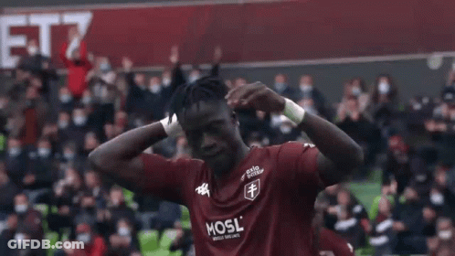 A Group Of Soccer Players Are Hugging Each Other On A Soccer Field . GIF