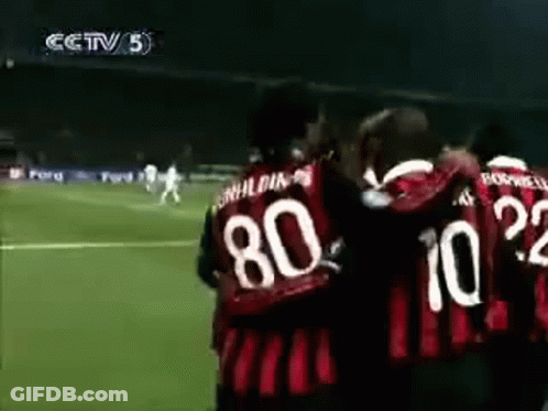 A Group Of Soccer Players Are Hugging Each Other On A Soccer Field . GIF