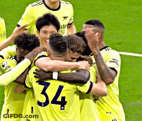 A Group Of Soccer Players Are Hugging Each Other On The Field . One Of The Players Has The Number 34 On His Shirt . GIF