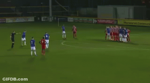 A Group Of Soccer Players Are Playing A Game On A Field With A Goal In The Background . GIF