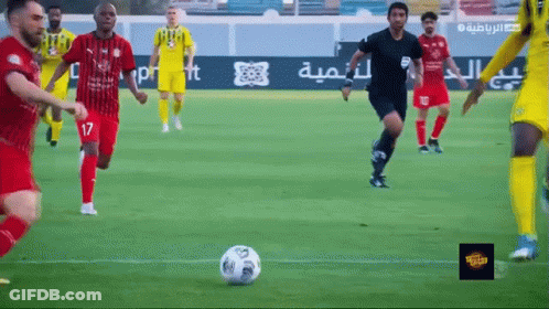 A Group Of Soccer Players Are Playing A Game On A Field With Arabic Writing On The Sidelines GIF