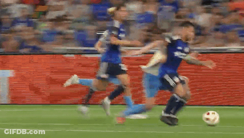 A Group Of Soccer Players Are Playing A Game On A Soccer Field . GIF