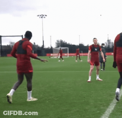 A Group Of Soccer Players Are Playing On A Field And One Of Them Is Wearing A Jersey That Says ' Liverpool ' GIF