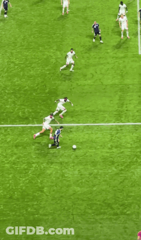 A Group Of Soccer Players Are Playing On A Field With A Goal In The Background GIF