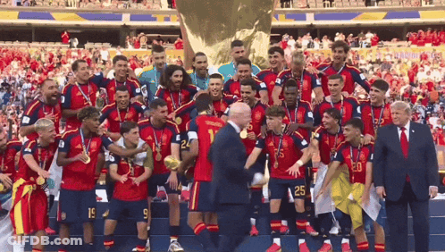A Group Of Soccer Players Are Posing For A Picture With A Man In A Suit With The Number 20 On His Shirt GIF