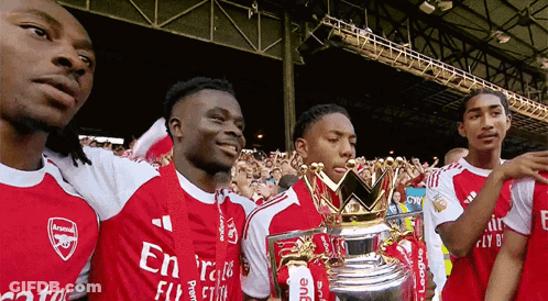 A Group Of Soccer Players Are Posing For A Picture With A Trophy That Says League On It GIF