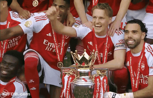 A Group Of Soccer Players Are Posing For A Picture With A Trophy That Says Premier League On It GIF