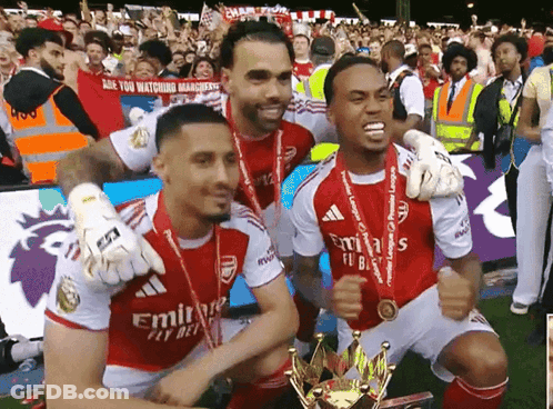 A Group Of Soccer Players Are Posing With A Trophy And A Sign That Says Are You Watching Management GIF