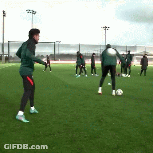 A Group Of Soccer Players Are Practicing On A Field With A Man Kicking A Soccer Ball GIF