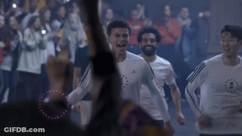 A Group Of Soccer Players Are Running In Front Of A Crowd Of People . GIF
