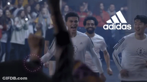 A Group Of Soccer Players Are Running In Front Of A Crowd With The Adidas Logo In The Background GIF