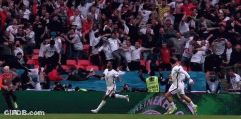 A Group Of Soccer Players Are Running On A Field In Front Of A Heineken Ad GIF
