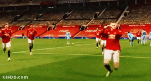 A Group Of Soccer Players Are Running On A Soccer Field In A Stadium . GIF
