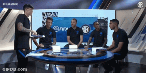 A Group Of Soccer Players Are Sitting Around A Table In Front Of A Fifa Logo GIF