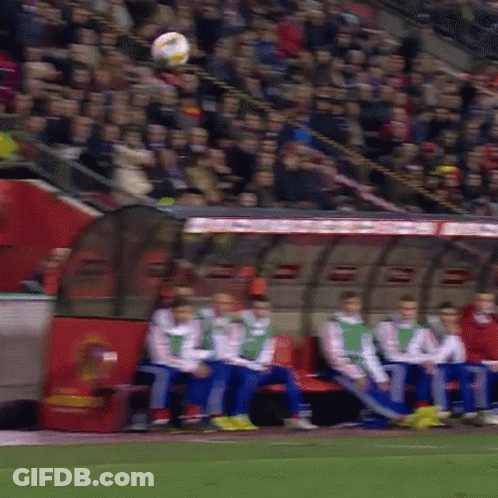 A Group Of Soccer Players Are Sitting In A Dugout Watching A Soccer Game GIF