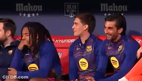 A Group Of Soccer Players Are Sitting On A Bench In A Locker Room . GIF