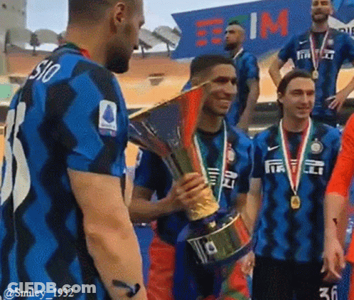 A Group Of Soccer Players Are Standing Around A Trophy And One Has The Number 36 On His Shirt GIF
