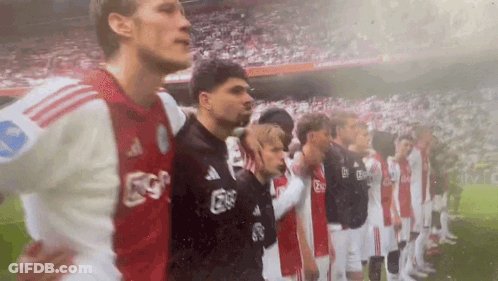 A Group Of Soccer Players Are Standing In A Line On The Field . GIF