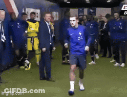 A Group Of Soccer Players Are Standing In A Locker Room And One Of Them Is Running . GIF
