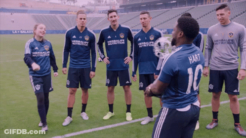 A Group Of Soccer Players Are Standing On A Field And One Of Them Is Wearing A Shirt That Says Hart GIF