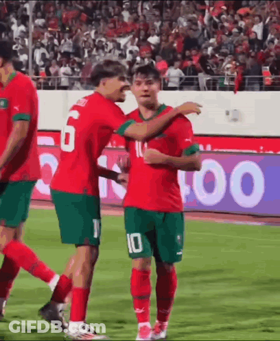 A Group Of Soccer Players Are Standing On A Field Hugging Each Other . GIF