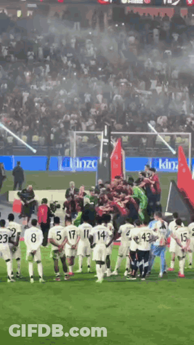 A Group Of Soccer Players Are Standing On A Field With A King Advertisement In The Background GIF