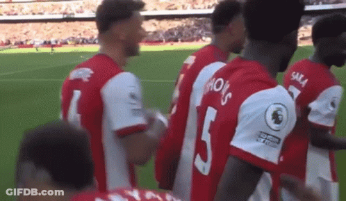 A Group Of Soccer Players Are Standing On A Soccer Field . GIF