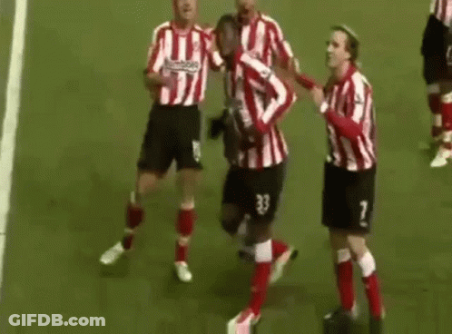 A Group Of Soccer Players Are Standing On Top Of A Soccer Field Celebrating A Goal . GIF