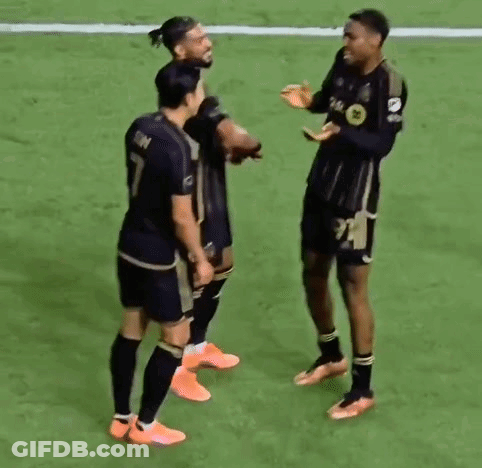 A Group Of Soccer Players Are Standing On Top Of A Soccer Field . GIF