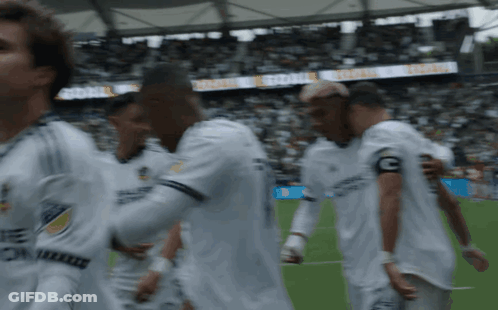 A Group Of Soccer Players Are Walking On A Field With A Banner Behind Them That Says " Global " GIF