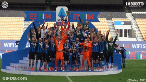 A Group Of Soccer Players Celebrate On A Podium With A Sign That Says Tim GIF