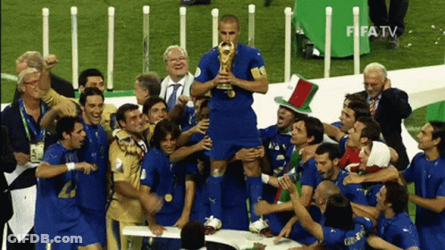 A Group Of Soccer Players Celebrate With A Man Holding A Trophy In Front Of Fifa TV GIF