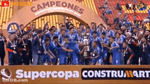 A Group Of Soccer Players Holding A Trophy In Front Of A Sign That Says Supercopa GIF