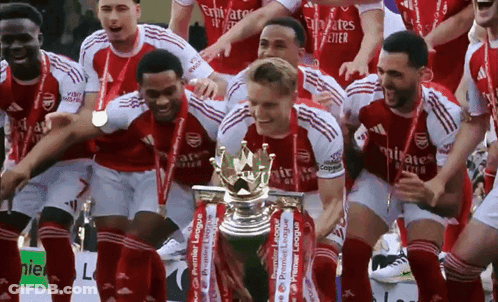 A Group Of Soccer Players Holding A Trophy With Emirates Written On Their Shirts GIF