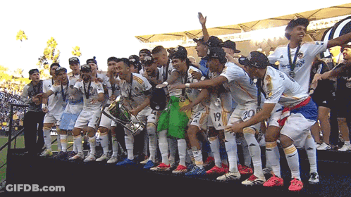 A Group Of Soccer Players Holding A Trophy With The Number 20 On The Back GIF