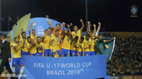 A Group Of Soccer Players Holding Up A Trophy In Front Of A Banner That Says Fifa U-17 World Cup Brazil 2019 GIF
