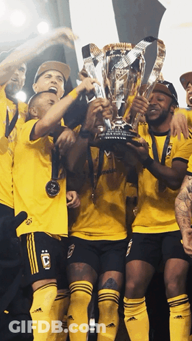 A Group Of Soccer Players Holding Up A Trophy With The Letter C On Their Jerseys GIF