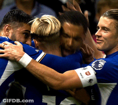 A Group Of Soccer Players Huddle Together With One Wearing A Wristband That Says ' Reebok ' On It GIF