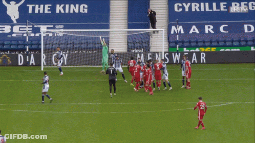 A Group Of Soccer Players On A Field In Front Of A Men 'S Wear Ad GIF