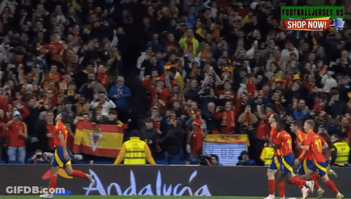 A Group Of Soccer Players On A Field With A Banner That Says Andalucia GIF