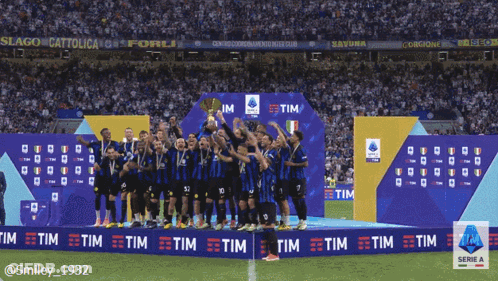 A Group Of Soccer Players Stand On A Podium Holding A Trophy In Front Of An Ad For Tim GIF