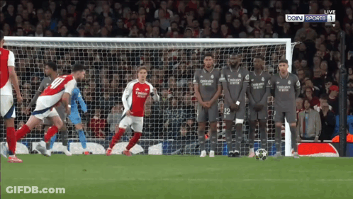 A Group Of Soccer Players Wearing Emirates Jerseys Stand In Front Of A Soccer Goal GIF