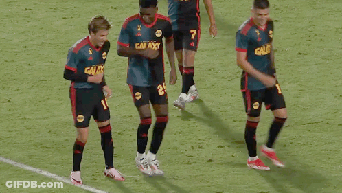 A Group Of Soccer Players Wearing Galaxy Jerseys Are Dancing On The Field GIF